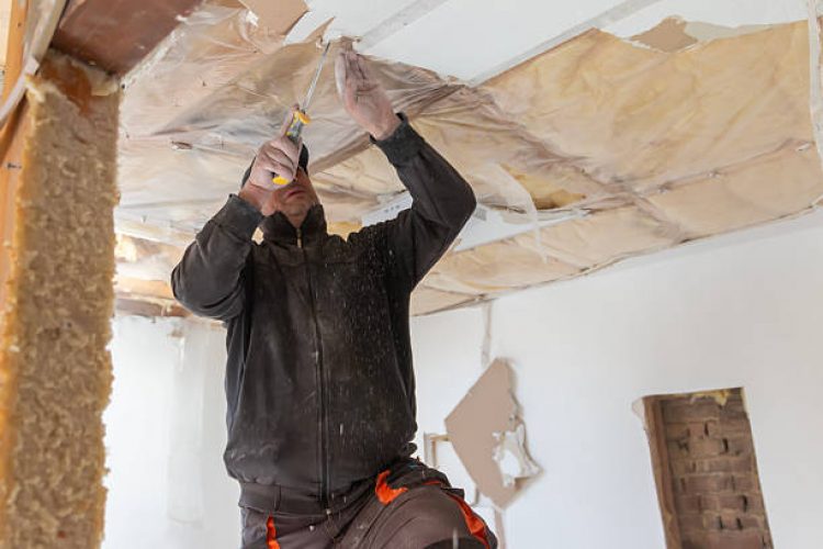 Mature man  working on renovation demolition of house. Real construction worker working on a house renovation - authentic person on the job. House improvement concept.