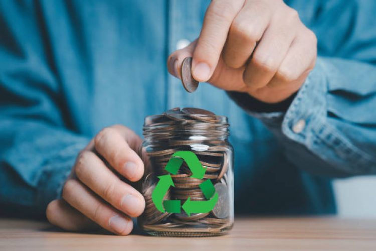 Businessman holding coin and input to fully money saving jar with recycle sign for recycle to increase business profit concept.