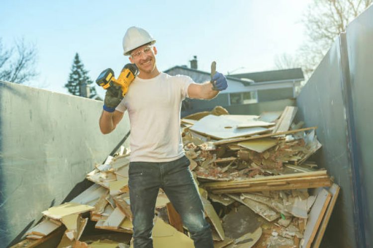 A Construction Worker put old renovation material on big conteiner