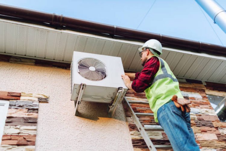Technician in uniform repairing heat pump Technician in uniform repairing heat pump