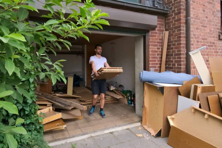 Young, caucasian, white, 30 years old man carrying out bulky waste to the sidewalk
