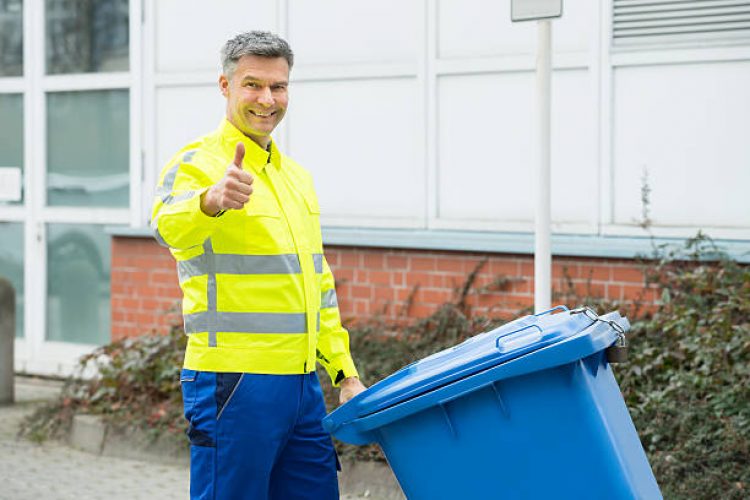 Mature Happy Working Man Holding Dustbin On Street